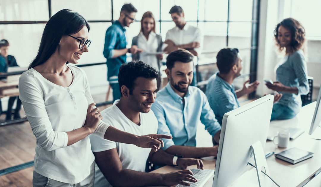 People in an office looking at a computer